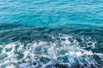 Deep blue water with shore foam, background photo taken from coast of Cyprus island, Mediterranean Sea
