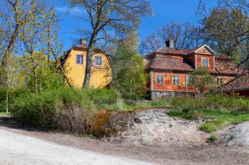 Swedish rural landscape, colorful old wooden houses on green hill