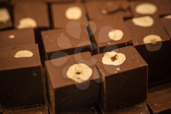 Dark chocolate blocks with hazelnuts on the counter. Macro photo with selective focus