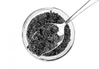 Black caviar in a glass jar with spoon. Top view isolated on white background