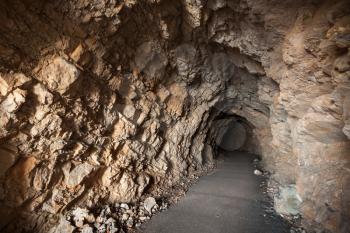 Asphalt road goes through the cave in the dark