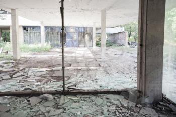 Abandoned industrial building interior. Concrete columns and broken windows