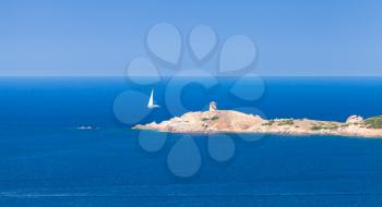 Sailing yacht goes near rocky coast of Corsica island. Summer panoramic seascape