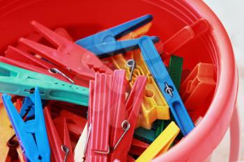 Colorful plastic clothespins in the bucket