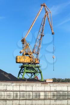 Big industrial harbor crane stands on the river coast in Bulgarian port