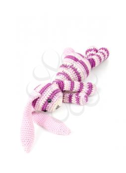 Sad knitted rabbit toy lays isolated on white background with soft shadow