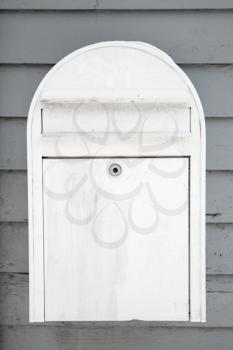 White mailbox on gray wooden wall, closeup photo