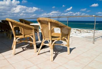 Wicker chairs on seaside terrace of a summer restaurant