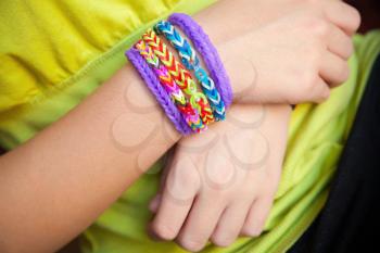 Child hands with Colorful rubber rainbow loom band bracelets, trendy kids fashion accessories