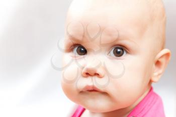 Little sad brown eyed baby closeup studio portrait