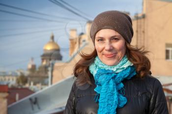 Outdoor portrait of young smiling Caucasian woman on the roof in Saint-Petersburg, Russia