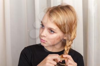 Blond Caucasian girl braids plait, closeup studio portrait