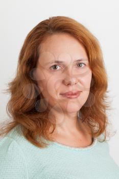 Young Caucasian woman, closeup studio portrait on light gray background