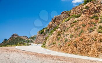 South Corsica landscape, turning mountain road and mountains under blue sky