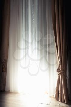 Abstract empty interior fragment, curtains and closed blinds with bright back light spot