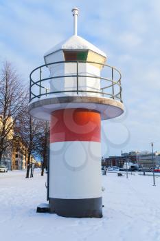 Red and white lighthouse tower in port of Turku, Finland. Cold winter day