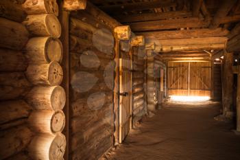 Ancient rural Russian interior, corridor with walls made of rough logs and glowing end