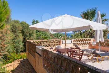 Seaside balcony with white umbrella. Zakynthos island, Greece, popular touristic resort 