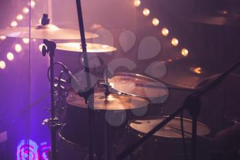 Live music photo background, rock drum set  with cymbals and colorful blurred stage lights
