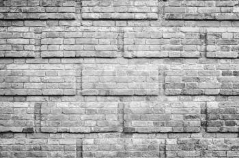 Old gray brick wall with decorative rectanglular relief pattern, background photo texture