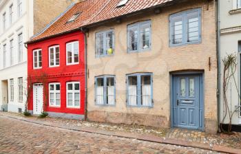 Traditional colorful living houses stand along street in old town of Flensburg city, Germany