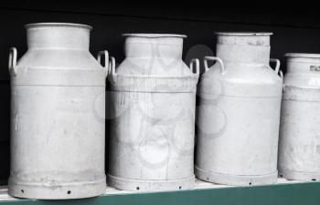 Metal milk churns stand in a row