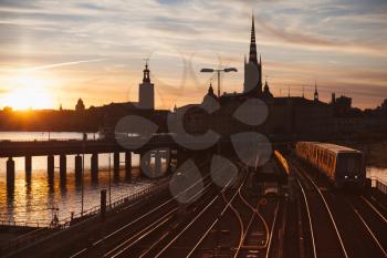 Evening cityscape with subway train crossing the bridge of Gamla Stan, Stockholm, Sweden