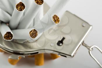 Heap of cigarettes locked to handcuffs. Closeup view