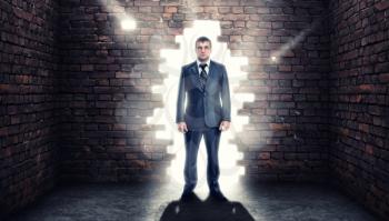 Coming confident businessman standing in wall hole
