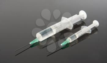 Two syringes on gray surface