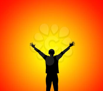 Silhouette of man lifting hands to sunset