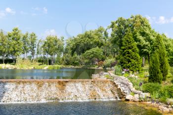 Beautiful lake with waterfall in green park