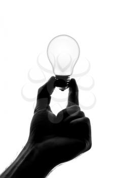 Silhouette of hand holding dull bulb. Isolated on white