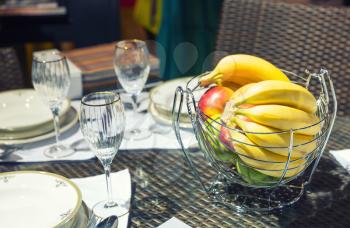 Close up table with glasses and vase for fruits