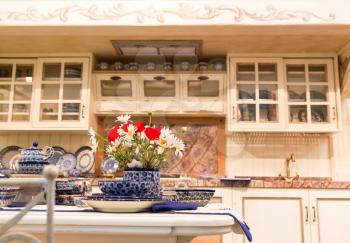 Luxury kitchen made from light wood with kitchen tools and flowers