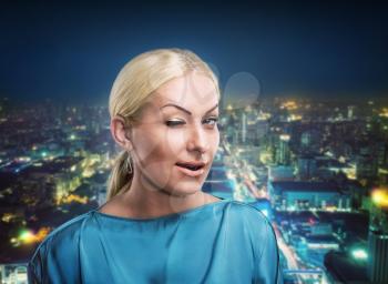 Young businesswoman winking against night city background