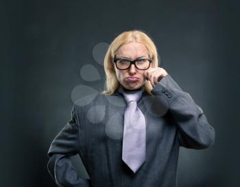 Funny nerd businesswoman in glasses over grey background