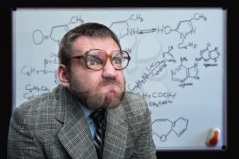 Bizarre professor in glasses thinking over chemical formulas