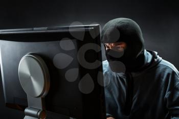 Hacker in mask is stealing information