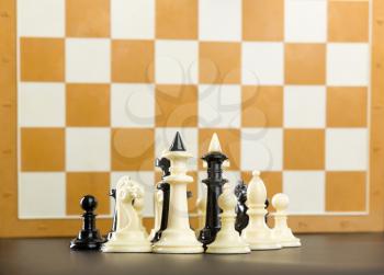 Chess figures standing against the board