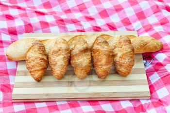 Croissants and French bread for picnic on the board