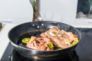 Meat with kiwi fruit on the frying pan