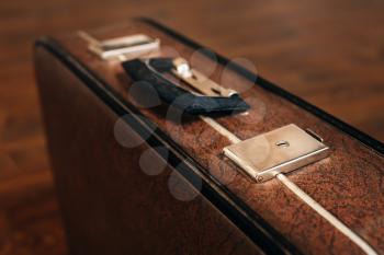 Closed retro suitcase on the wooden floor. Vintage travel concept.