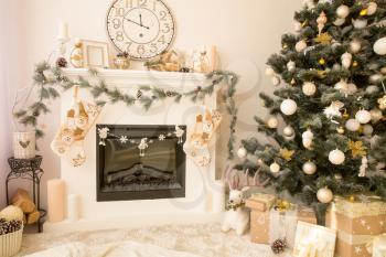Christmas decorated house interior with fireplace, wall clock, xmas tree and presents under it. Merry xmas and new year concept.