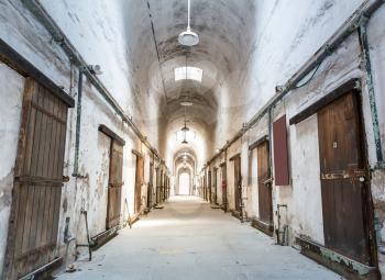 Old grunge prison. Prison cells with locked wooden doors.