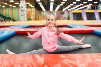 Flexible girl on playground in childrens entertainment center. Child sport activity. Happy childhood