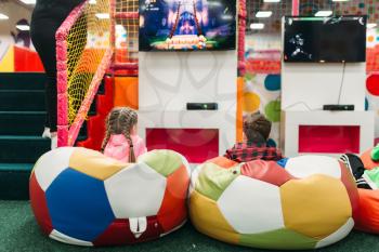 Boy and girl play in a games console in childrens entertainment center. Happy childhood