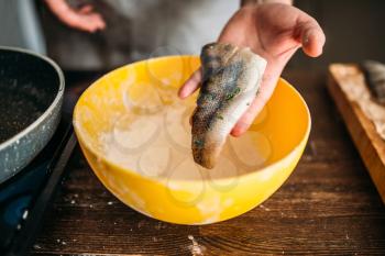 Male chef hands cooking fish on a frying pan. Food cooking. Seafood preparation