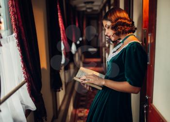 Young woman travels, vintage train compartment. Old wagon interior. Railway journey, railroad voyage