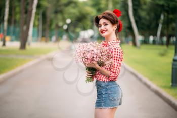 Pinup girl with bouquet of flowers, retro american fashion. Cute smiling woman in pin up style